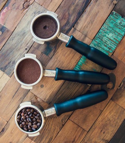 coffee portafilter, coffee beans, tamped coffee grind, used coffee puck